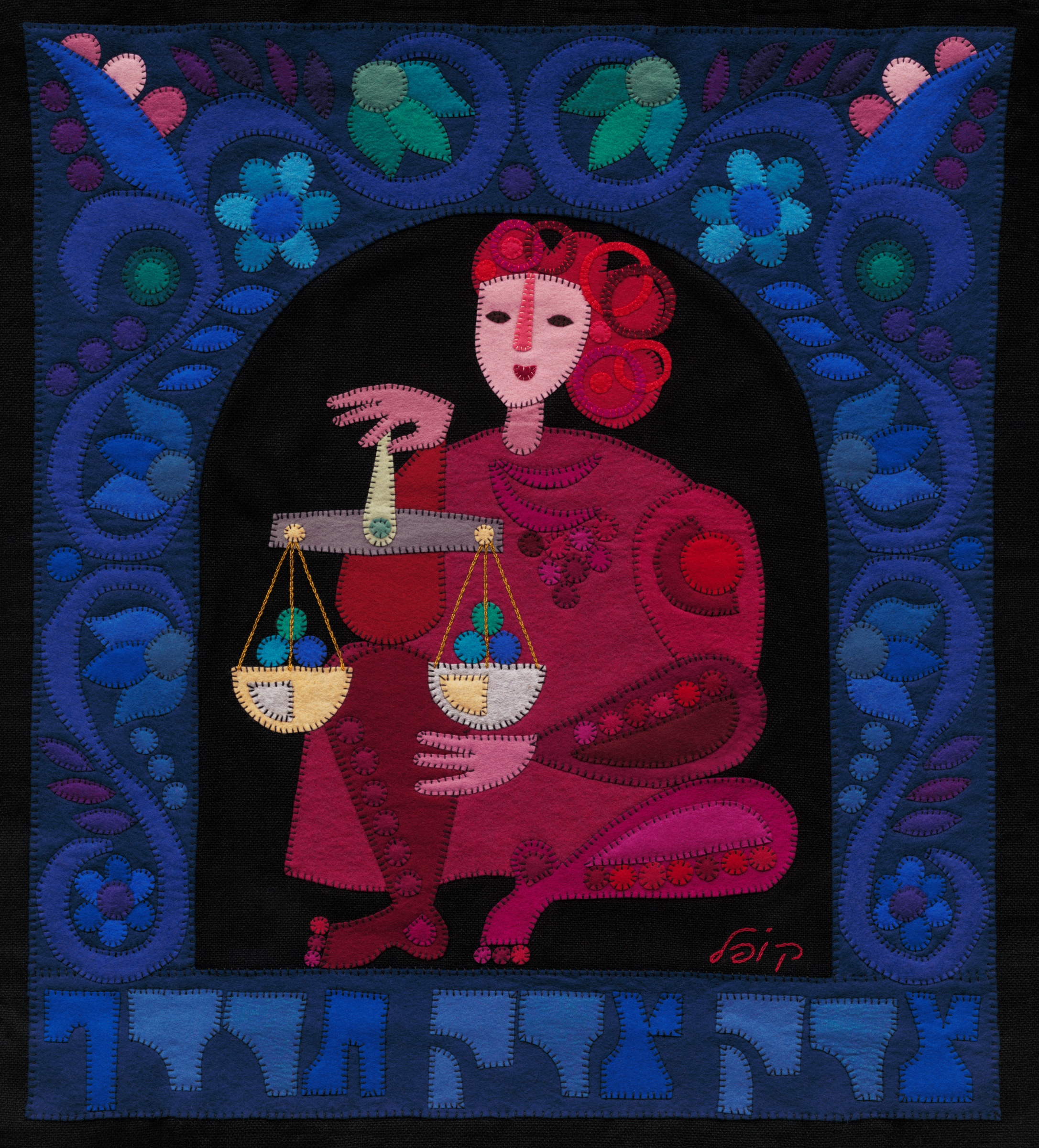 Justice Justice by Kopel Gurwin, a hand-cut felt appliqué depicting a seated woman dressed in crimson and magenta, holding a balance scale with two suspended pans. The figure appears against a black background beneath an ornate blue floral arch, with large Hebrew lettering along the lower edge of the composition.