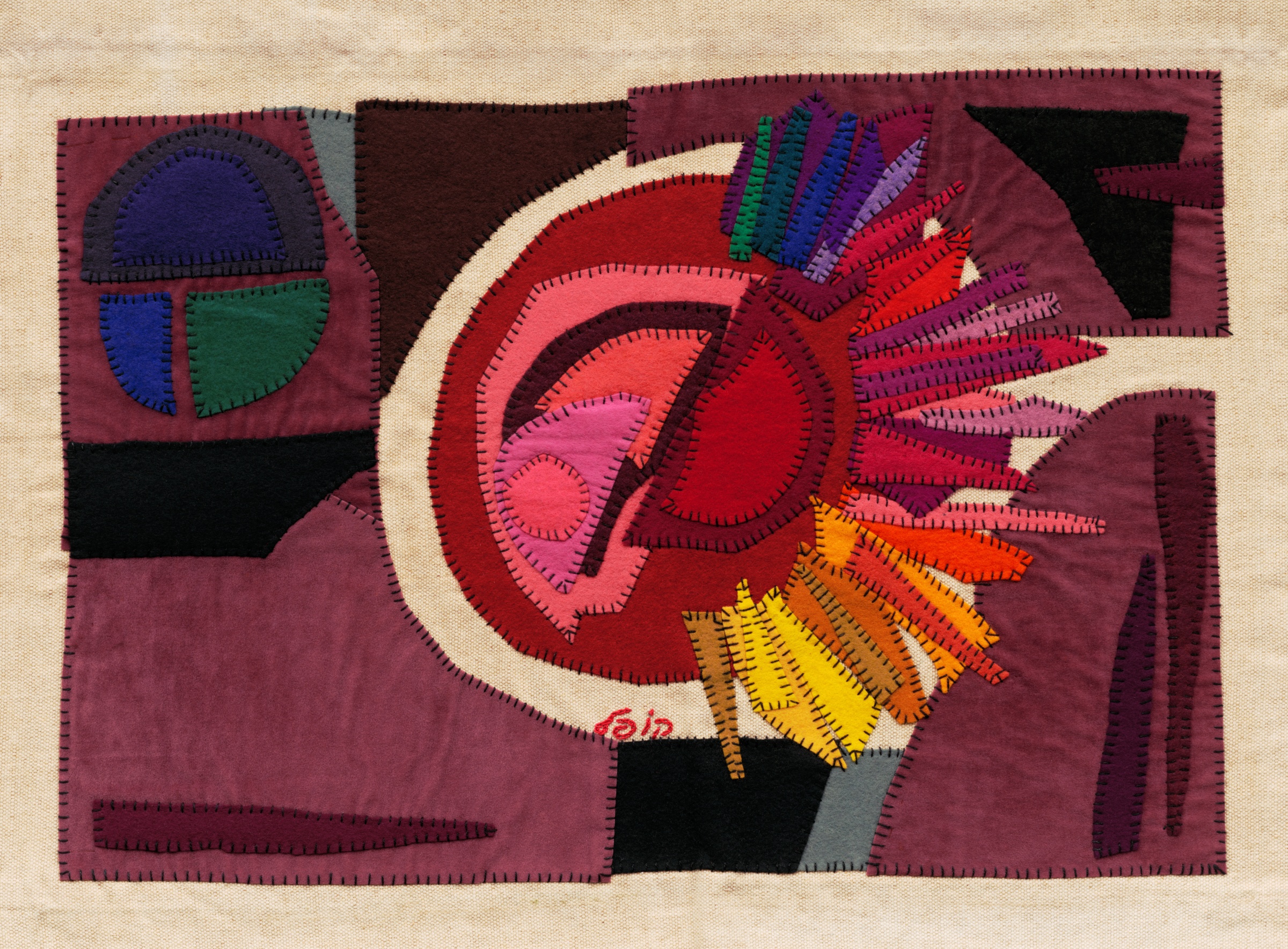 The Sun by Kopel Gurwin, an abstract hand-cut felt appliqué featuring a large circular composition in red, coral, and pink, intersected by angular forms in yellow, orange, purple, and blue. Geometric felt panels in burgundy, black, and muted green surround the central motif against a natural beige textile background.