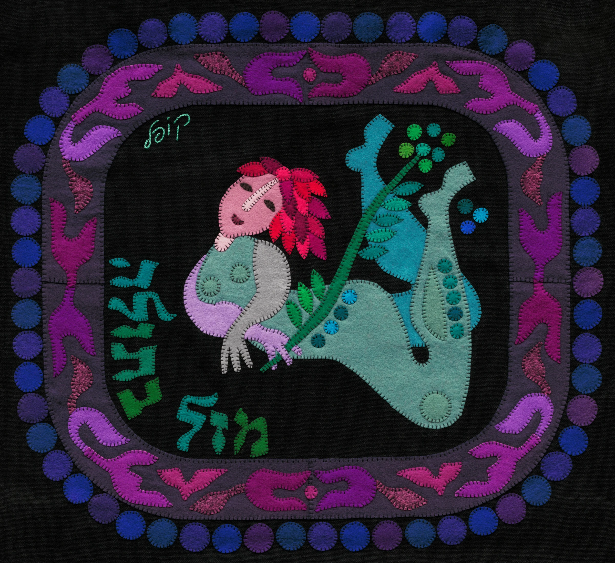 Virgo by Kopel Gurwin, a hand-cut felt appliqué depicting a stylized maiden holding a flowering branch. The figure is rendered in soft turquoise, mint green, lavender, and pink against a dark background, surrounded by an ornamental border of purple, magenta, and blue motifs. Hebrew lettering identifies the zodiac sign as Mazal Betula.
