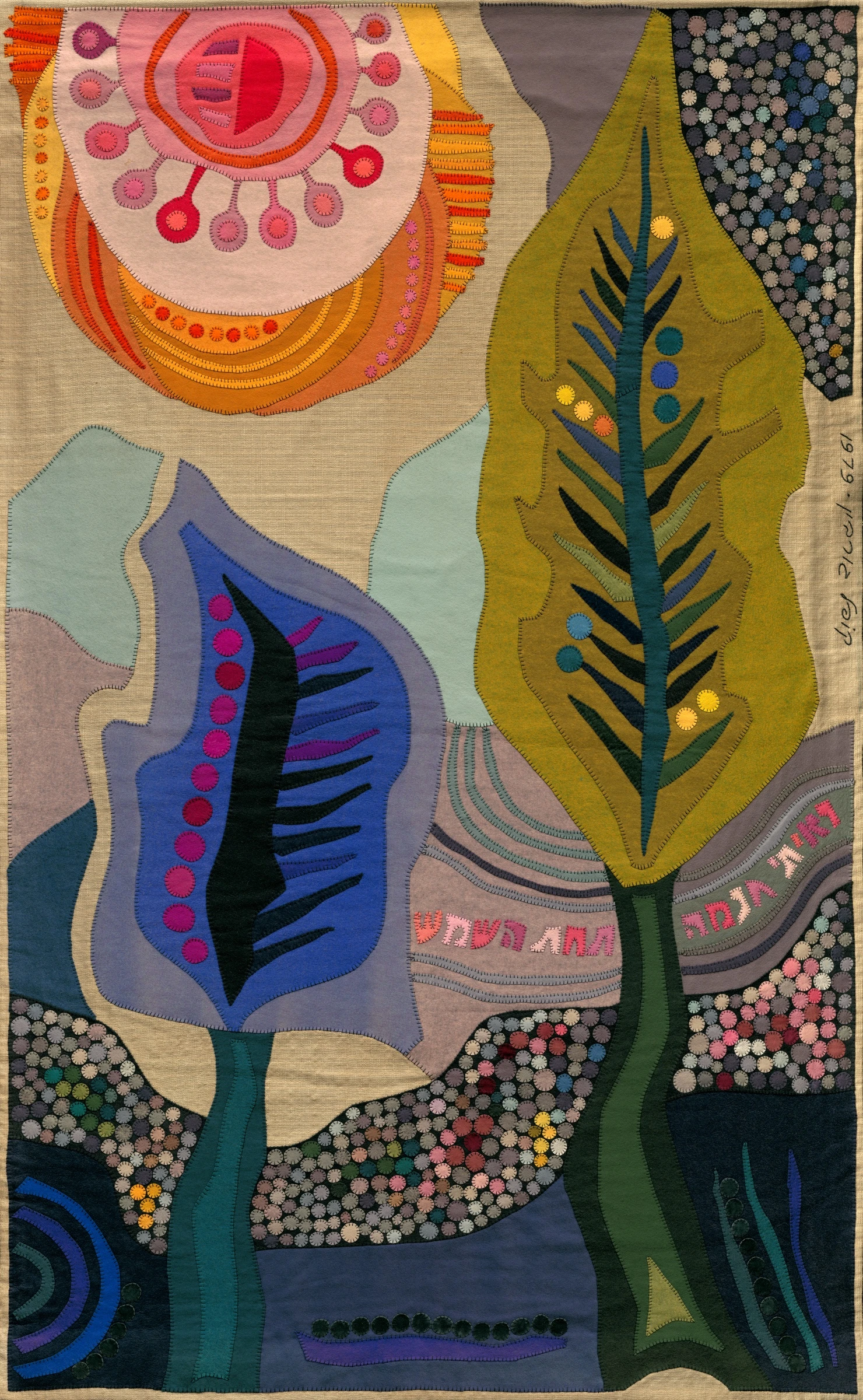 Wisdom under the Sun by Kopel Gurwin, an abstract hand-cut felt appliqué featuring two stylized trees beneath a large pink and orange sun. Layered foliage in blue, green, and olive tones rises above a landscape of densely patterned circular motifs, with a Hebrew inscription flowing through the composition.