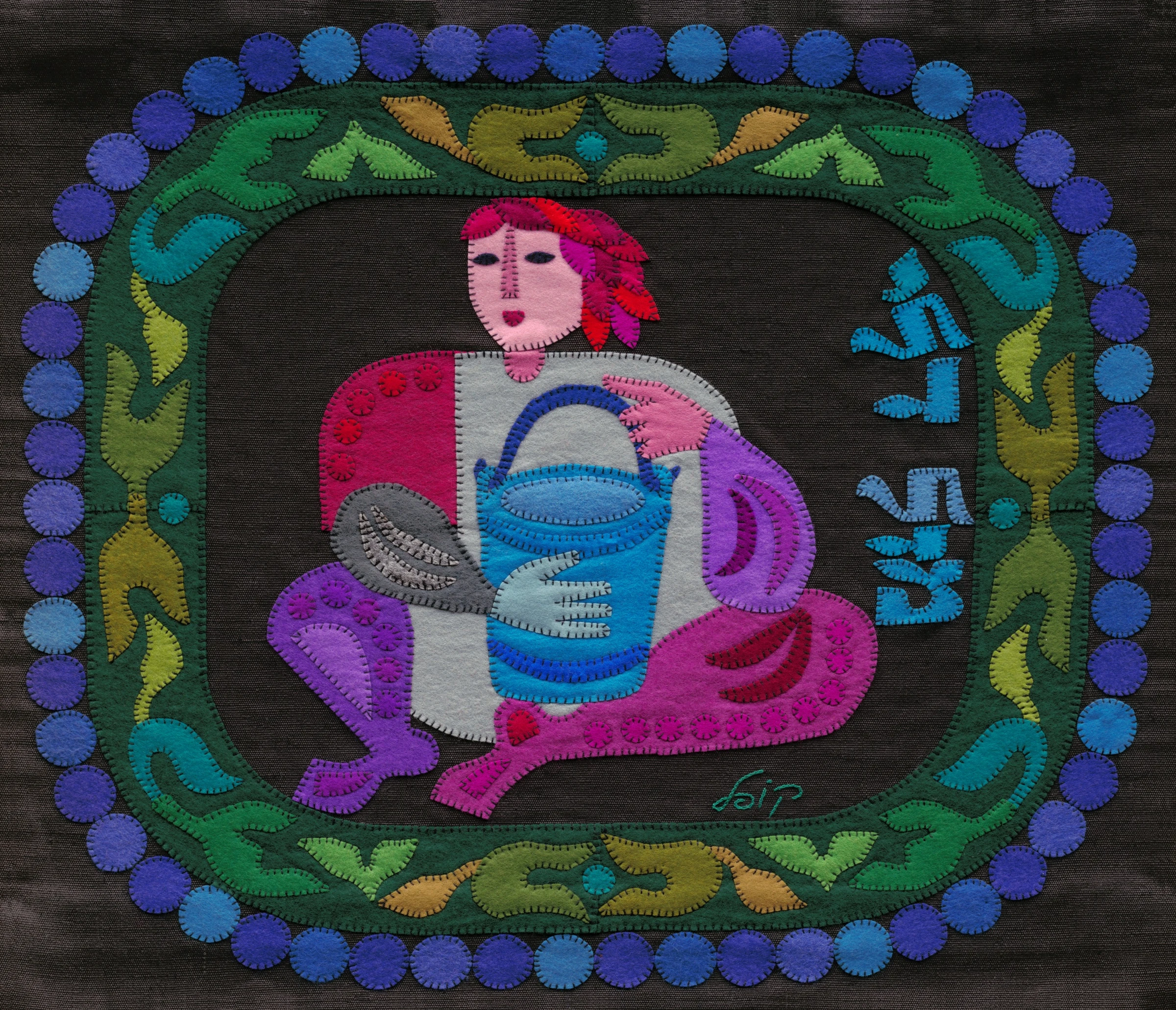 Aquarius by Kopel Gurwin, a hand-cut felt appliqué depicting a stylized water-bearer seated within an ornamental circular frame. The figure holds a bright blue vessel, while blue Hebrew lettering at the right identifies the sign as Mazal Dli. The composition is rendered in vivid pinks, purples, greens, and blues against a dark ground.